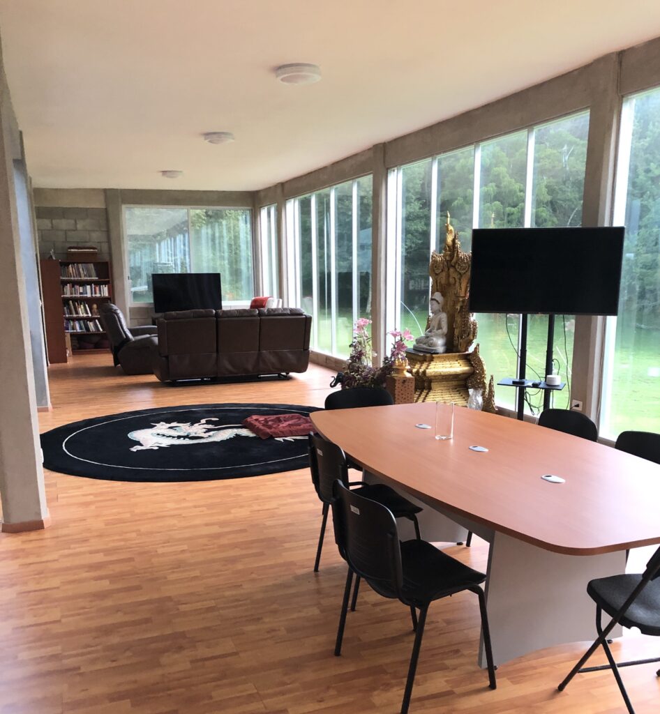 Sala de meditación y estudio del Dhamma Vihāra, con ventanales al bosque