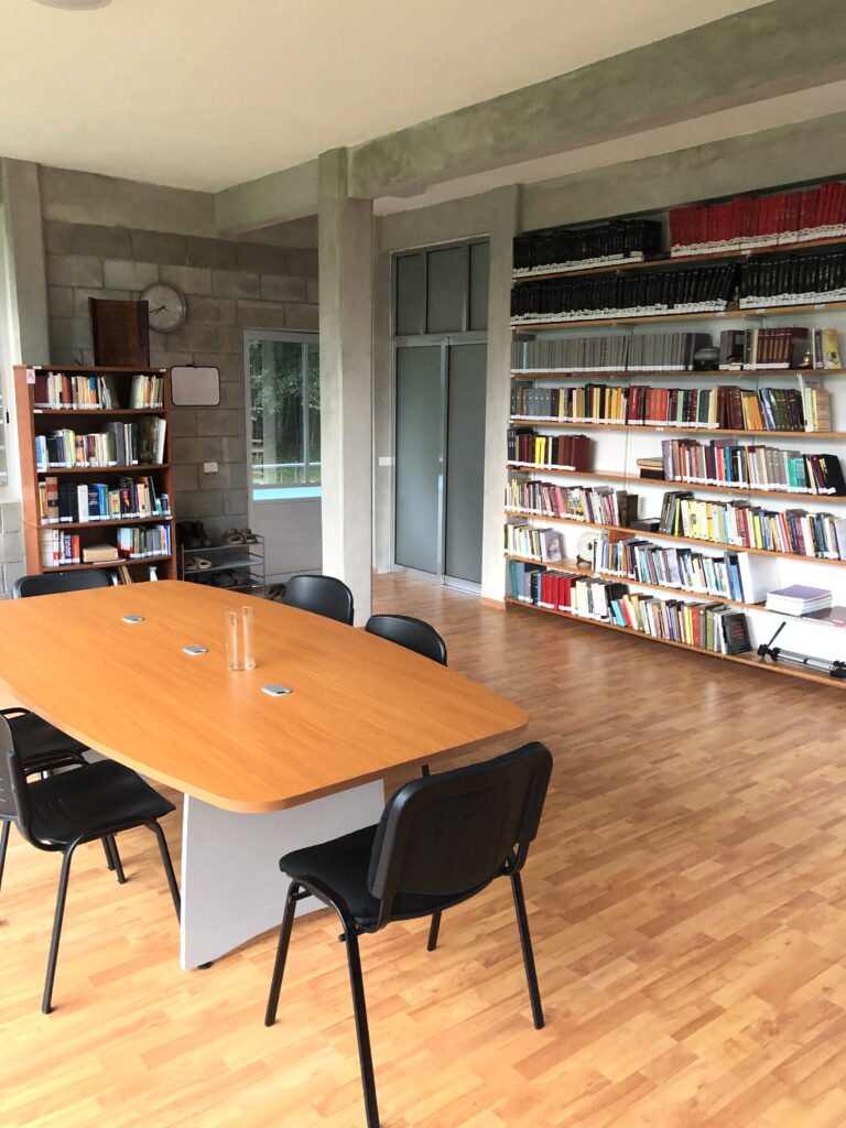Biblioteca del Dhamma Vihāra: estantes de libros y mesa de trabajo